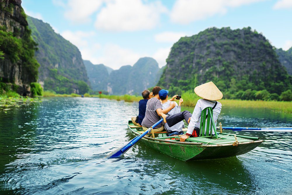family in boat travelling down river in vietnam