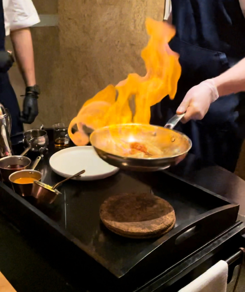 scampi in a flaming pan being tossed by a chef