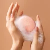 Hands holding Foreo Body Luna device with suds