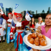 People holding honey puffs and greek flags celebrating paniyiri Brisbane