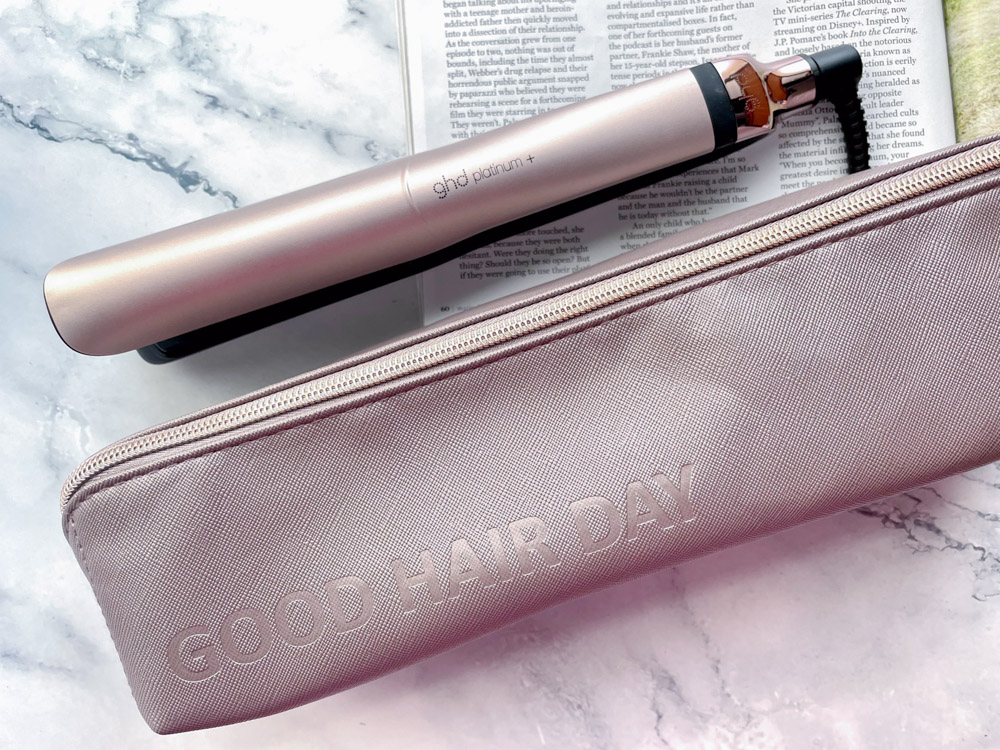 Luxury taupe and rose gold ghd platinum plus straightener on a marble background.