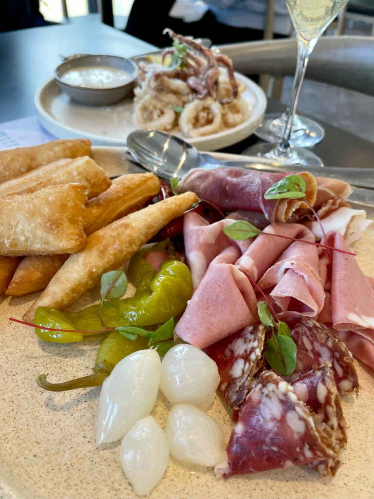 Salumi board in the foreground and calamari in the background.