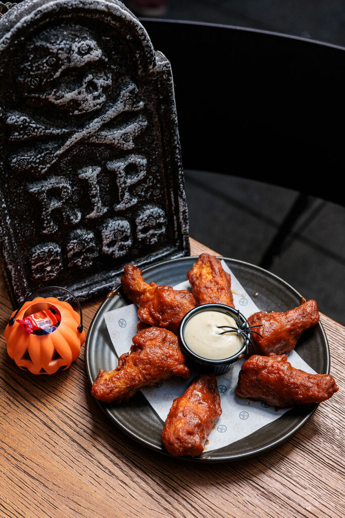 A gravestone and a creepy themed plate of chicken wings and drumettes