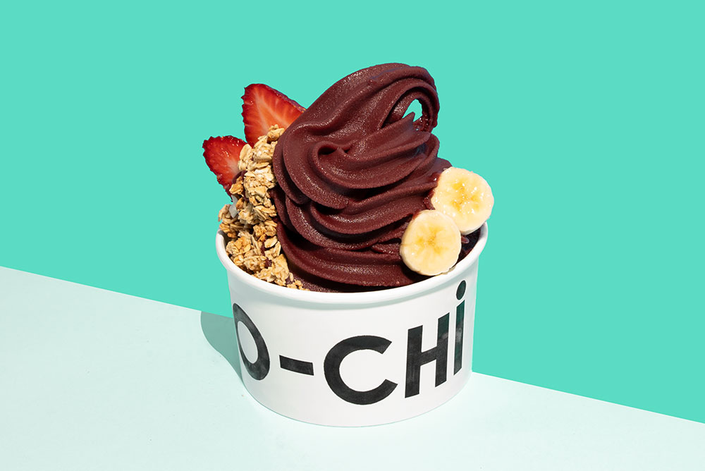 A Yo-Chi container filled with a swirl of acai yogurt, strawberries, banana and granola. 