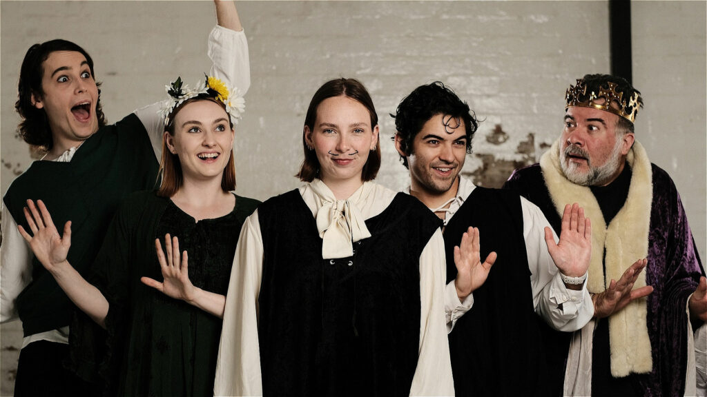 A group of five actors are dressed in Shakespearean clothes and are being expressive.
