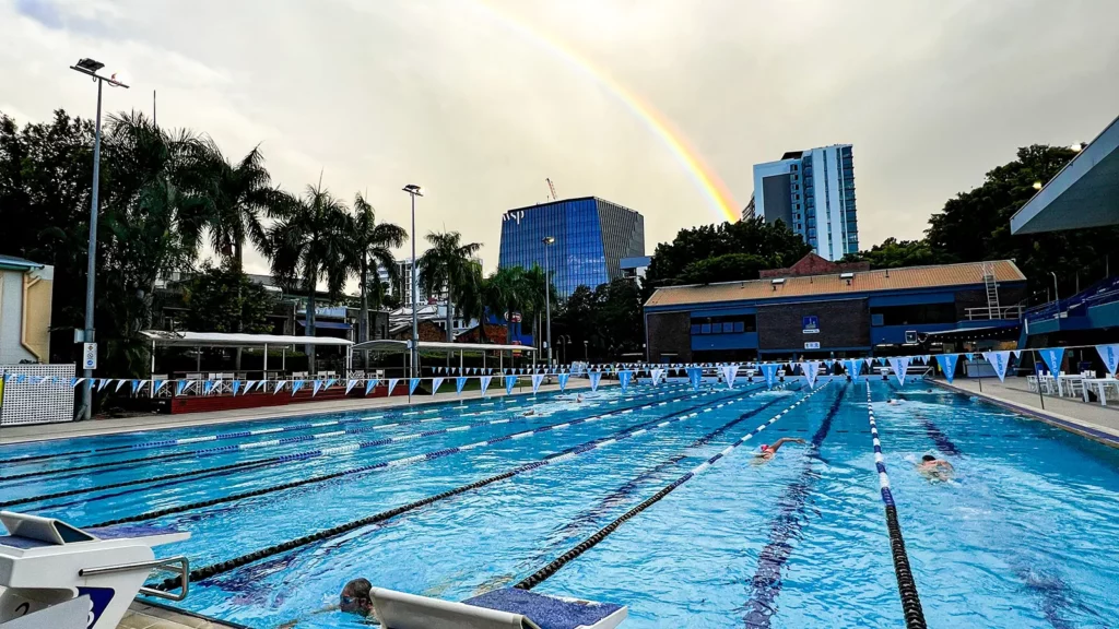 Rainbow over the top of a pool in the afternoon.