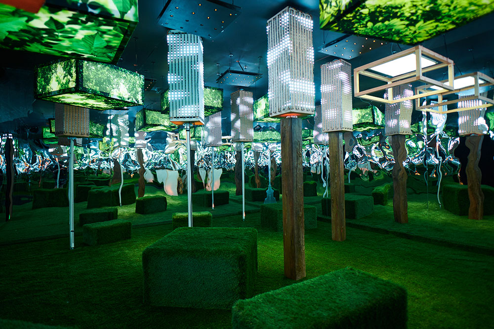 A green forest room featuring artificial trees and grass. 