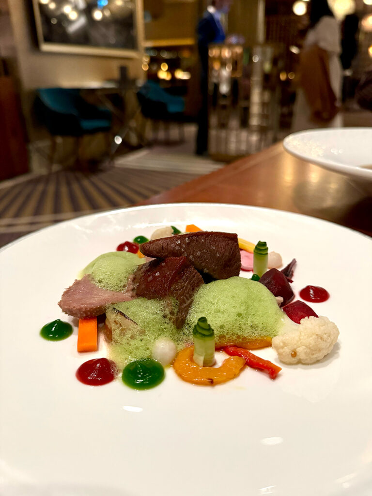 cuts of wagyu tongue rest on a bed of pickled vegetables in autumnal colours