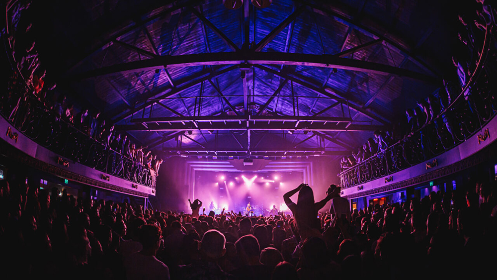 Crowds of people cheer on a band at The Tivoli.