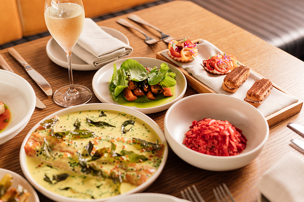 A table is filled with various french food dishes and wine.