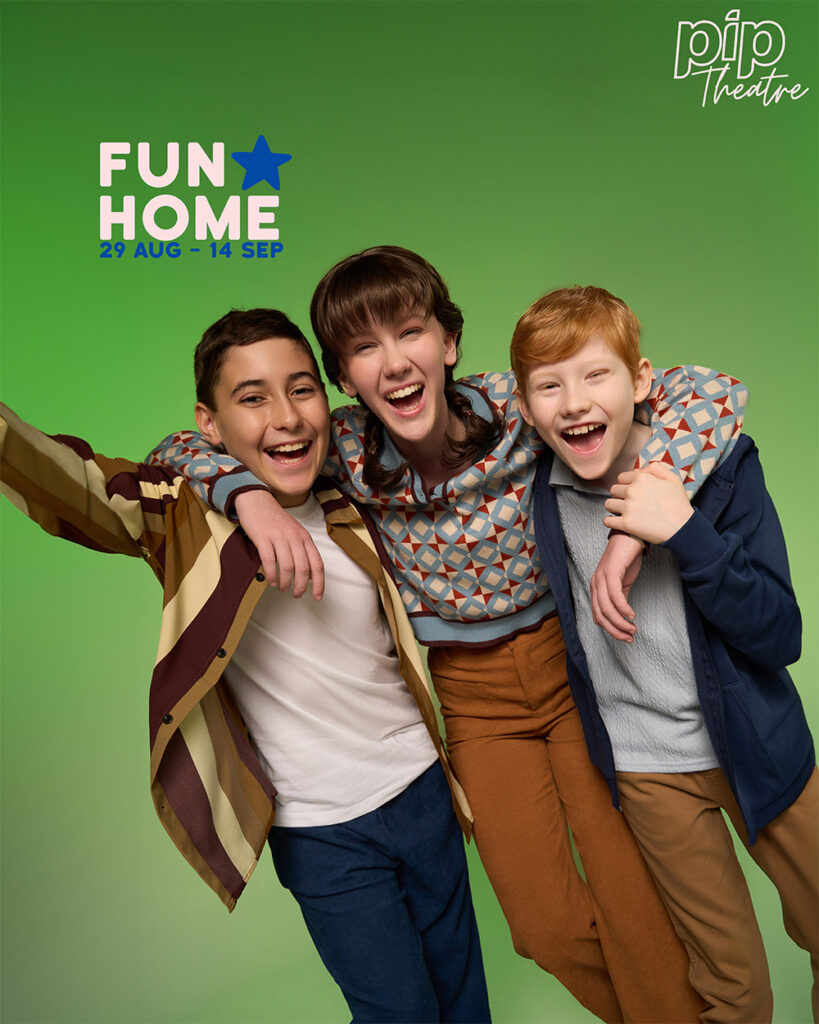 Three children smiling at the camera are laughing and linking arms