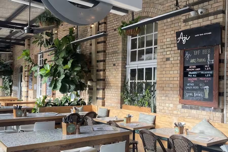 Tables and chairs sit out the front of a brick restaurant 