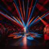 Greatest showman red and blue spotlights on one person in the middle of a circus ring